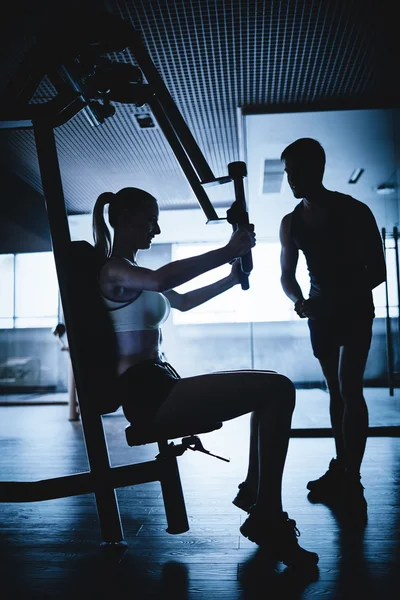 Vrouw uitoefenend met trainer in de sportschool — Stockfoto