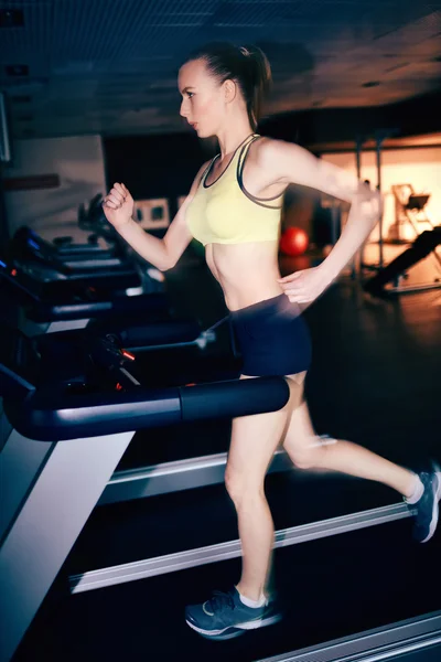 Frau läuft auf Laufband — Stockfoto