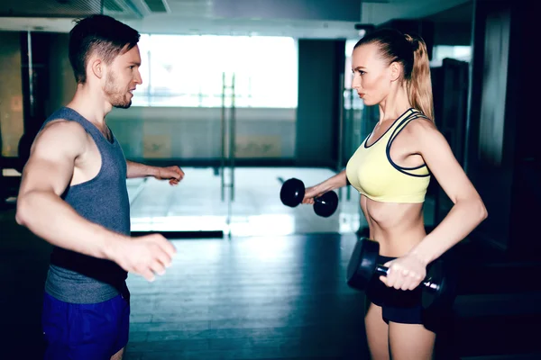 Mujer haciendo ejercicio con pesas con entrenador — Foto de Stock