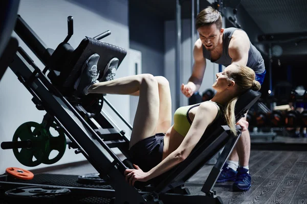 Mujer haciendo ejercicio para piernas con entrenador — Foto de Stock