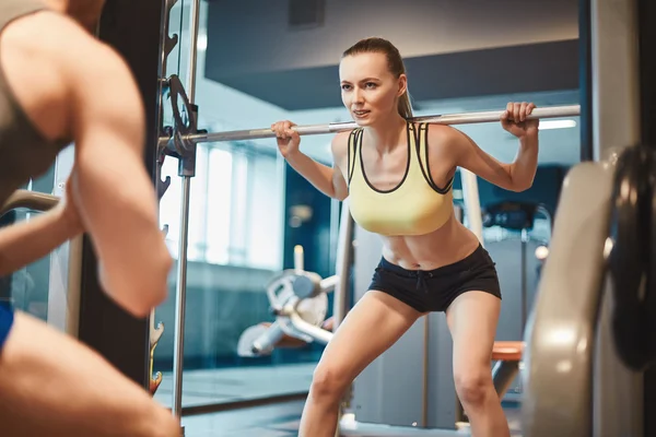 Mujer con peso mirando entrenador — Foto de Stock