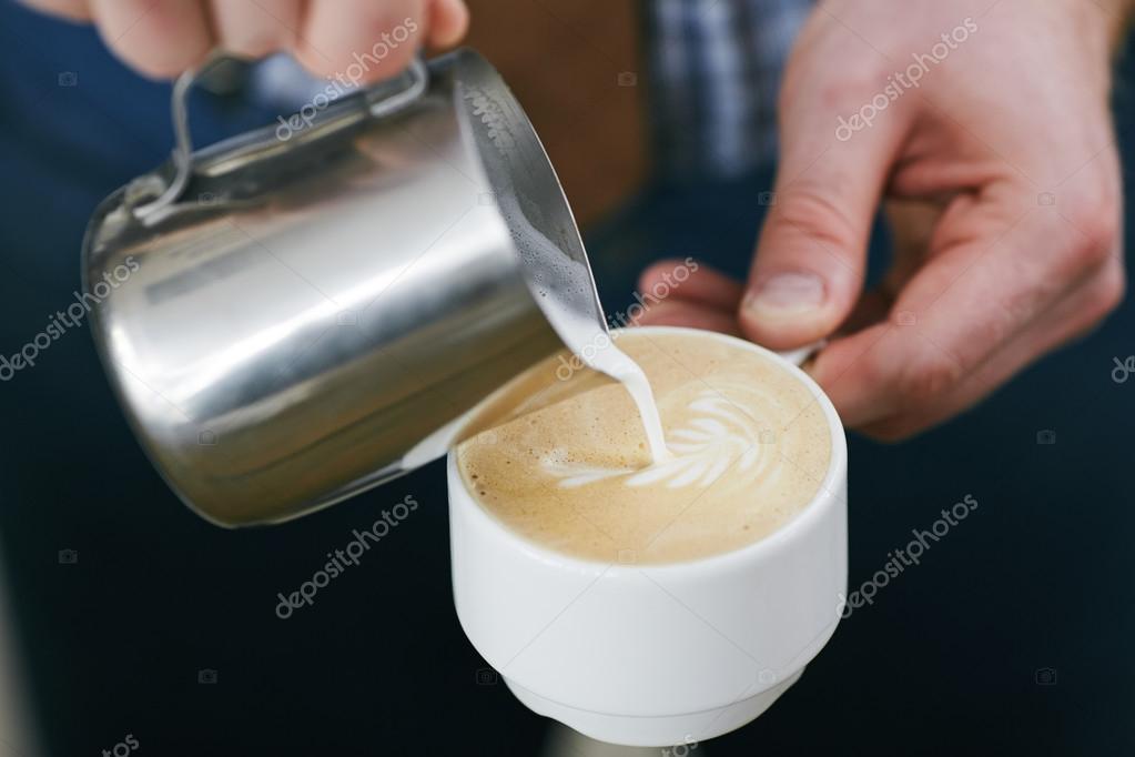 Barista pouring milk in cup with latte — Stock Photo © pressmaster 76972975