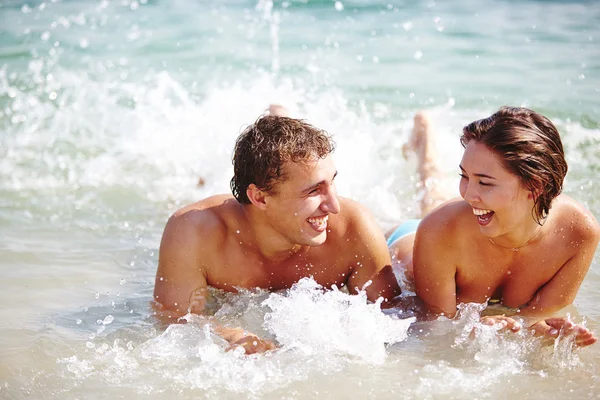 Couple splashing in water — Stock Photo, Image