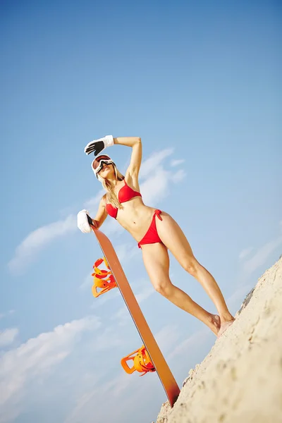 Vrouw in bikini houden snowboard — Stockfoto