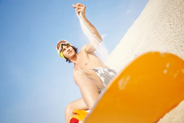 砂のビーチでサンドボードを持つ男 — ストック写真