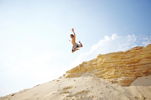 Man in jump over sandy beach — Stock Photo, Image