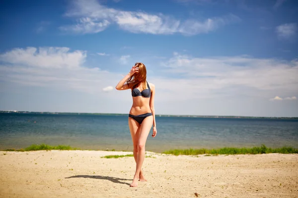 Kvinna i bikini på stranden — Stockfoto