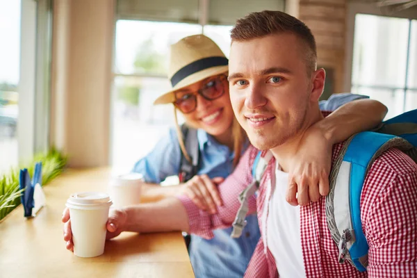 Couple with backpacks drink coffee — Stock Photo, Image