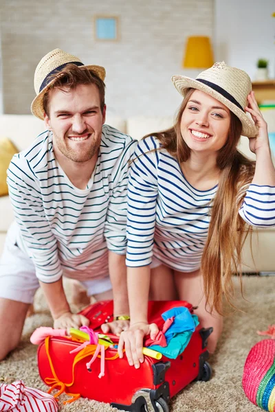 Viajeros empacando ropa en maleta — Foto de Stock