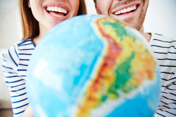 Casal com sorrisos de dentes e globo — Fotografia de Stock