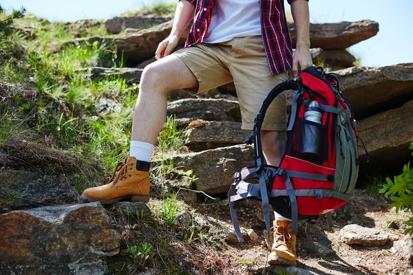 Viajero hombre con mochila en roca — Foto de Stock