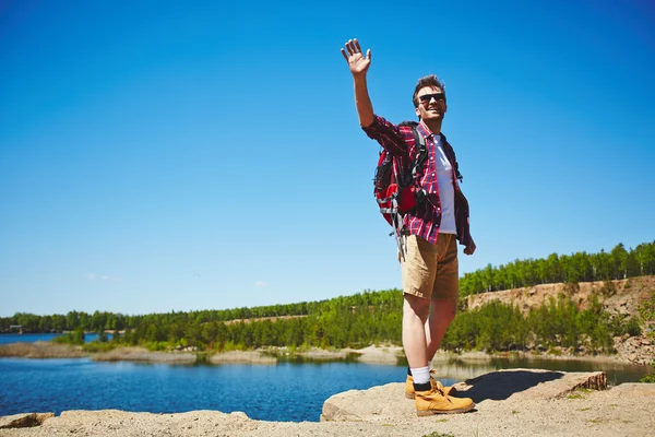 Reisender mit Rucksack steht auf Felsen — Stockfoto