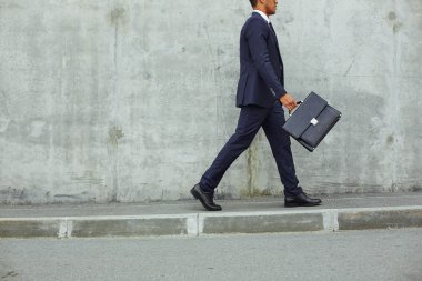 işadamı beton duvarı boyunca yürüyüş takım elbiseli