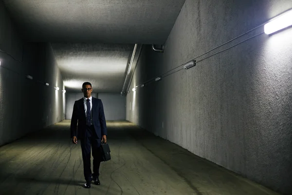 Biznesmen z teczki schodząc w dół tunelu — Zdjęcie stockowe