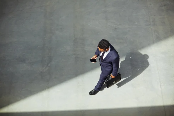 Homem de negócios com pasta usando celular — Fotografia de Stock
