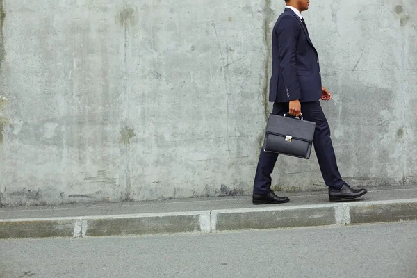 Affärsman promenader längs betongvägg — Stockfoto