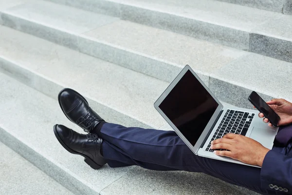 Uomo d'affari che utilizza laptop e smartphone — Foto Stock