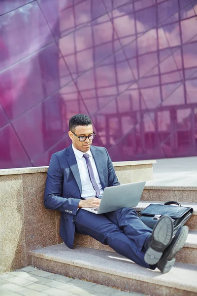 Businessman sitting on stairs with laptop — Stock Photo, Image