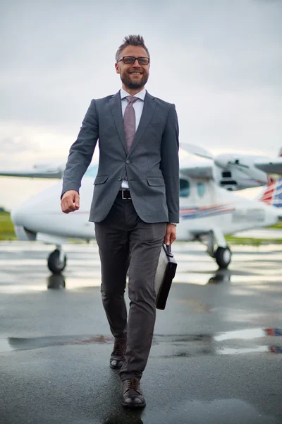 Бізнесмен з портфелем, що йде з літака — стокове фото