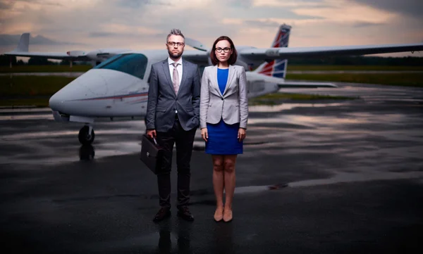 Medewerkers van het bedrijf met vliegtuig op achtergrond — Stockfoto