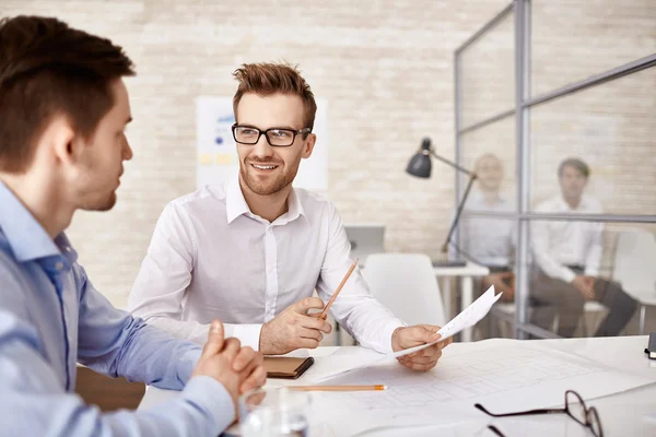 Businessman in eyeglasses talking to his co-worker — Stock Photo, Image