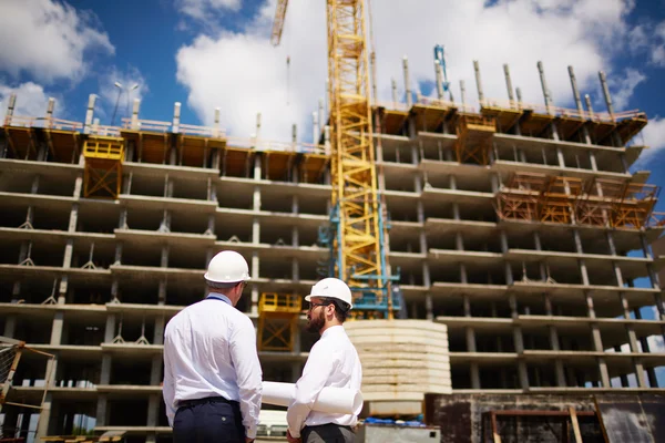 Arquitectos de pie frente a la nueva construcción — Foto de Stock