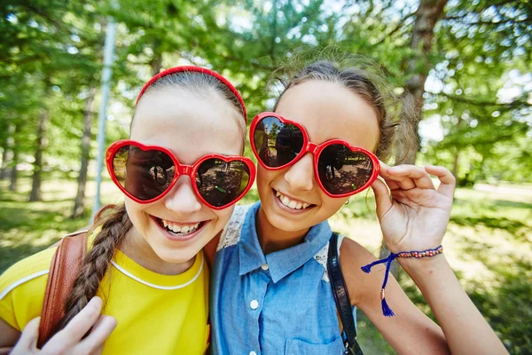 Meninas felizes em formas de coração óculos de sol — Fotografia de Stock