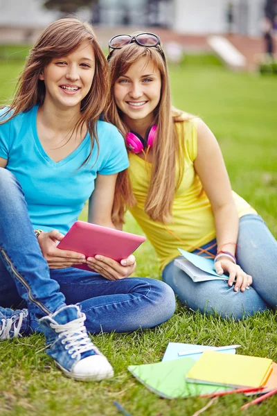Meisjes met touchpad op groene gazon — Stockfoto