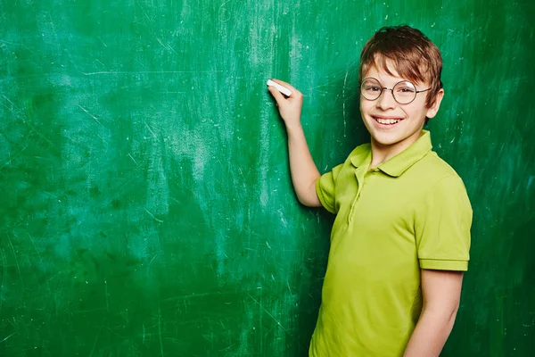 Yakışıklı çocuk tarafından kara tahta ayakta — Stok fotoğraf