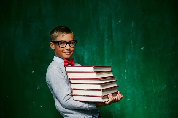 Хлопчик зі стопкою книг — стокове фото