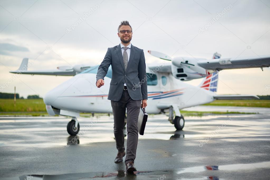 businessman with briefcase walking from airplane