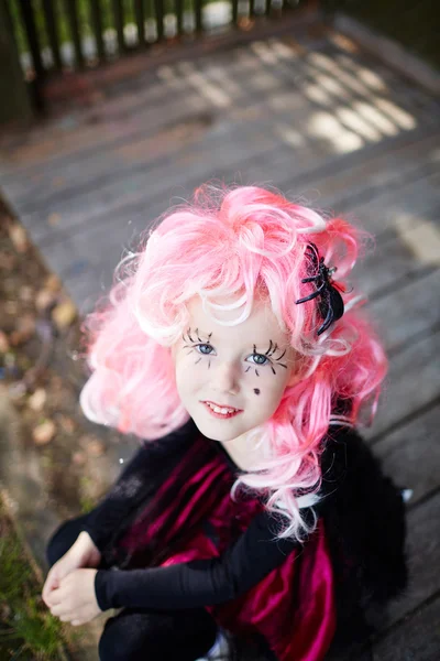 Niña con peluca rosa y pestañas pintadas — Foto de Stock