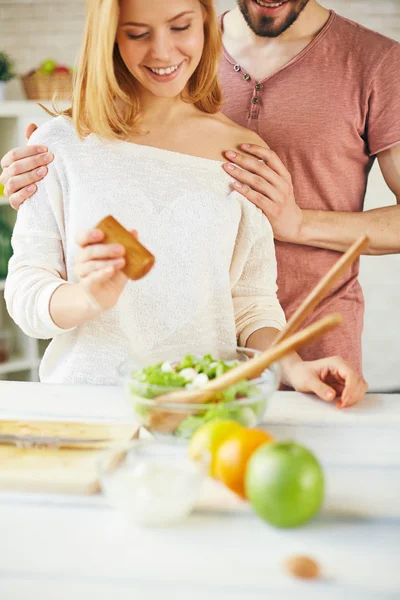 Woman salting vegetable salad — Stock Photo, Image