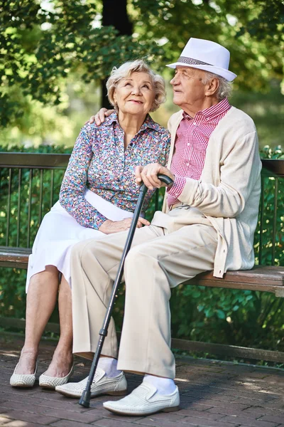 シニアカップル座ってベンチで公園 — ストック写真