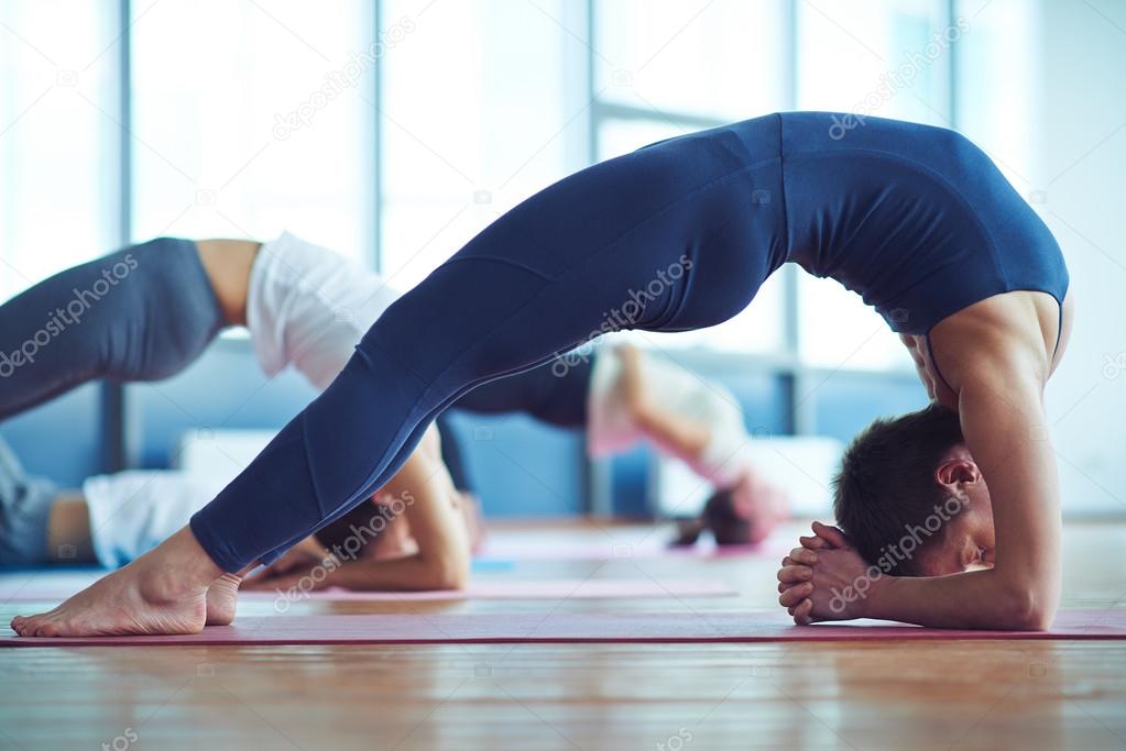 people doing stretching exercise in gym