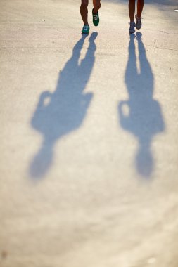 legs in sports-shoes and shadows