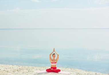 woman practicing yoga on beach clipart