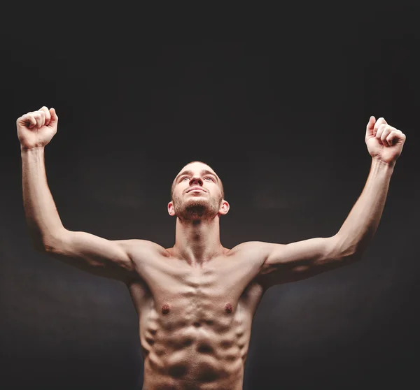 Muscular man with raised arms — Stock fotografie