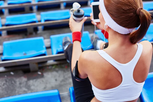 Kvinna i activewear sitter på stadium — Stockfoto