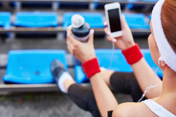 Wpman with earphones and smartphone at stadium — Stock Photo, Image