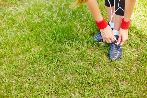 Sporty girl tying shoelaces — Stockfoto