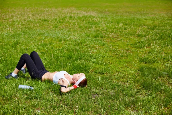 Kvinnan avslappnande på grön gräsmatta — Stockfoto