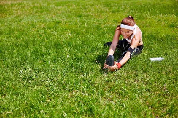 Woman exercising on green lawn — Stock Fotó
