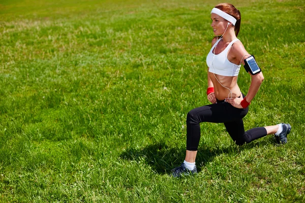 Sporty woman exercising in park — Stok fotoğraf