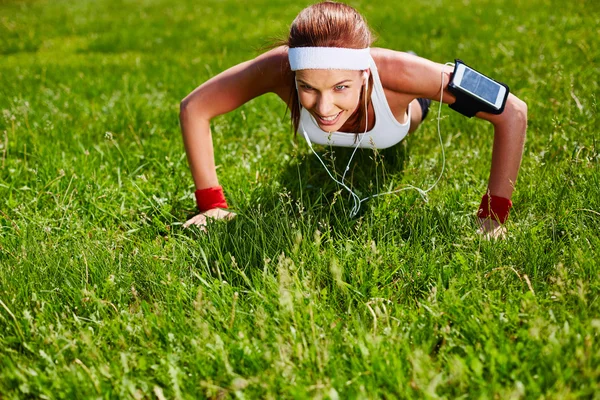 Woman doing exercises on grass — Stockfoto