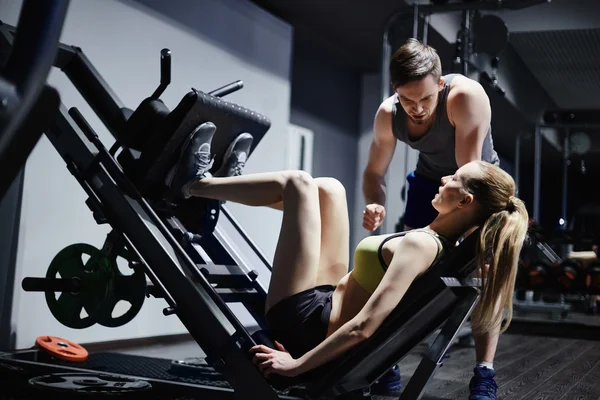 Mujer haciendo ejercicio para piernas con entrenador — Foto de Stock