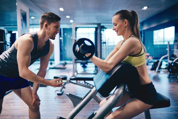 Mujer fortalecimiento de los músculos del brazo con entrenador — Foto de Stock