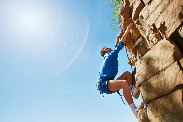 Homme grimpant sur un mont rocheux — Photo