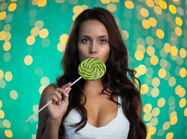 Woman with long hair licking lollipop — Stockfoto