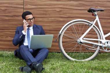 işadamı Çimenlikte oturan dizüstü bilgisayar ile